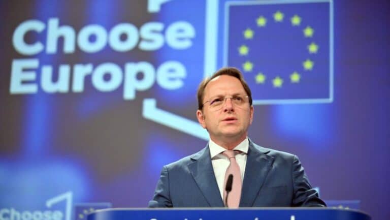 Europe választás, politikus beszéd, színpadon, háttérben az EU zászlók, döntéshozatal, fiatal férfi, hivatalos esemény.