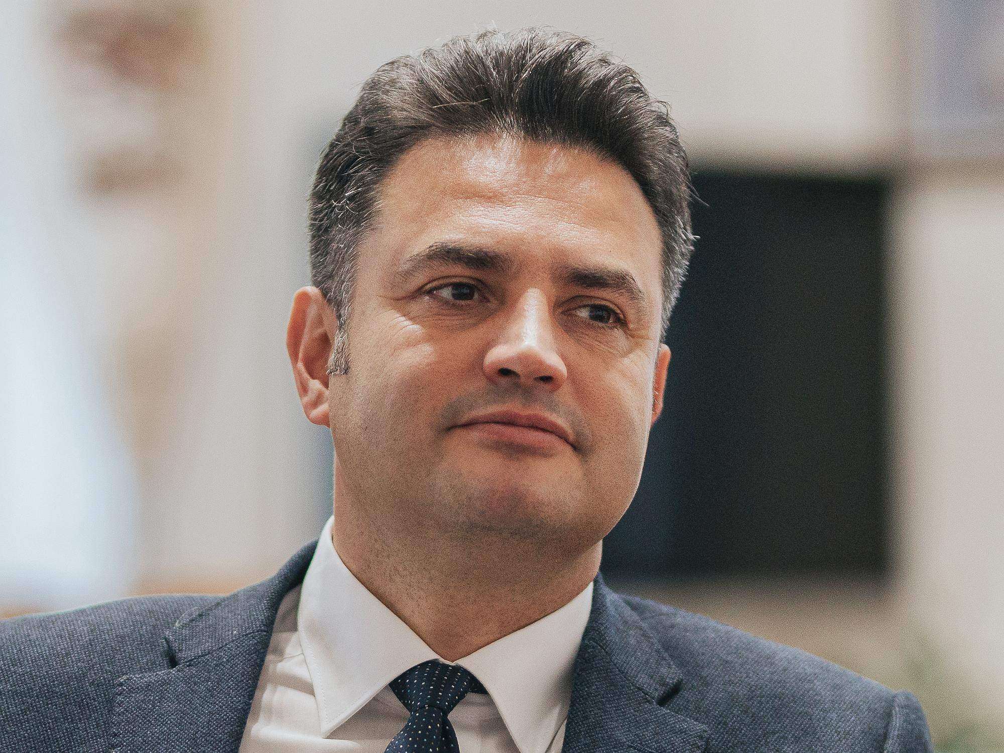 Vállalkozó férfi, üzleti öltözet, professzionális megjelenés, háttér, irodai környezet.