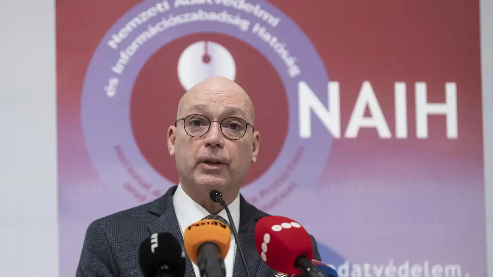 Nyilvános beszéd, politikus, sajtótájékoztató, mikrofonok, magyar nyelvű híroldal.