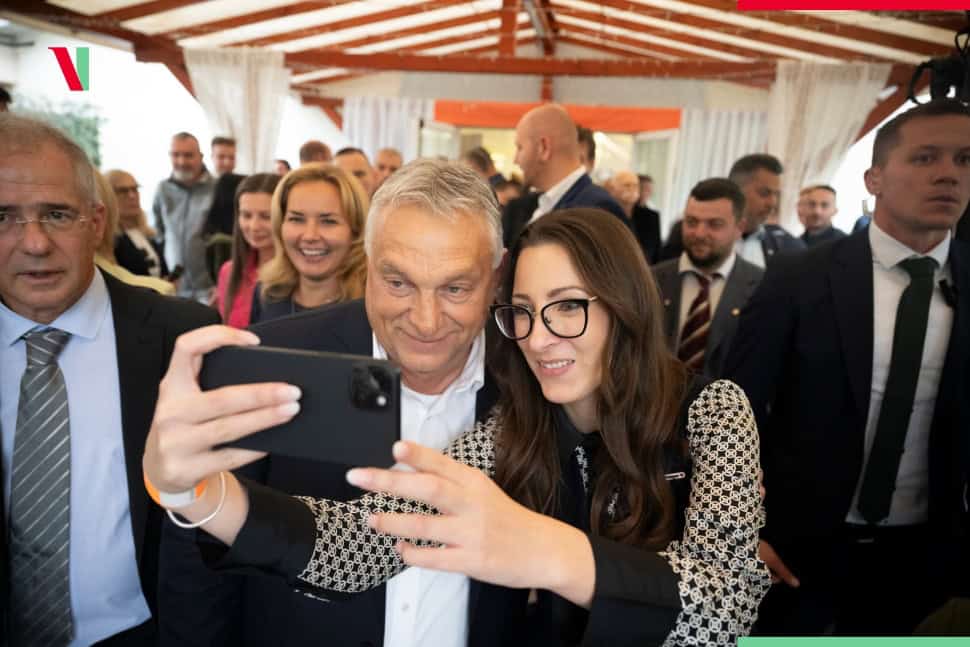 Fiatal nő és idősebb férfi selfie-t készítenek egy eseményen.