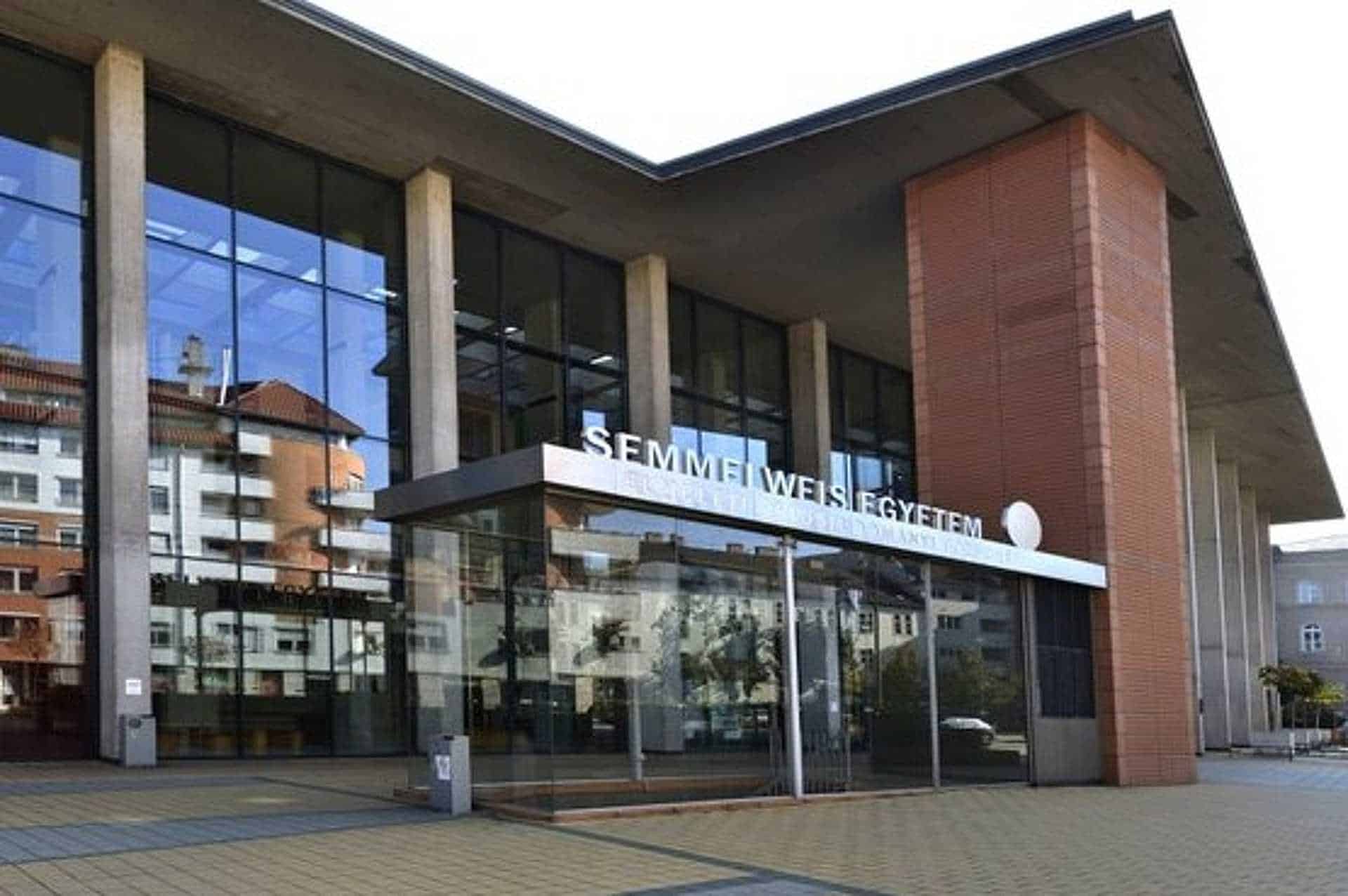 Szechenyi egyetem modern épülete, üvegfalak, a napfényben tükröződő városházi épületek.