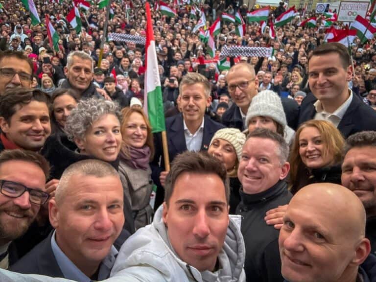 Fénykép több ember közös selfie-ről, sokan magyar zászlóval a háttérben.