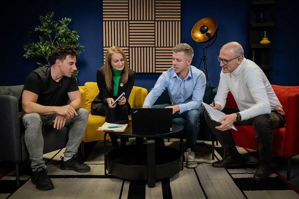 Egy fiatalokból álló csoport tárgyal vagy megbeszélést folytat modern stúdióban.