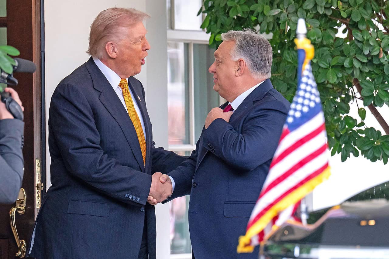Trump és Orbán Viktor kezében fogják egymást, egy elégedett és barátságos pillanatban.