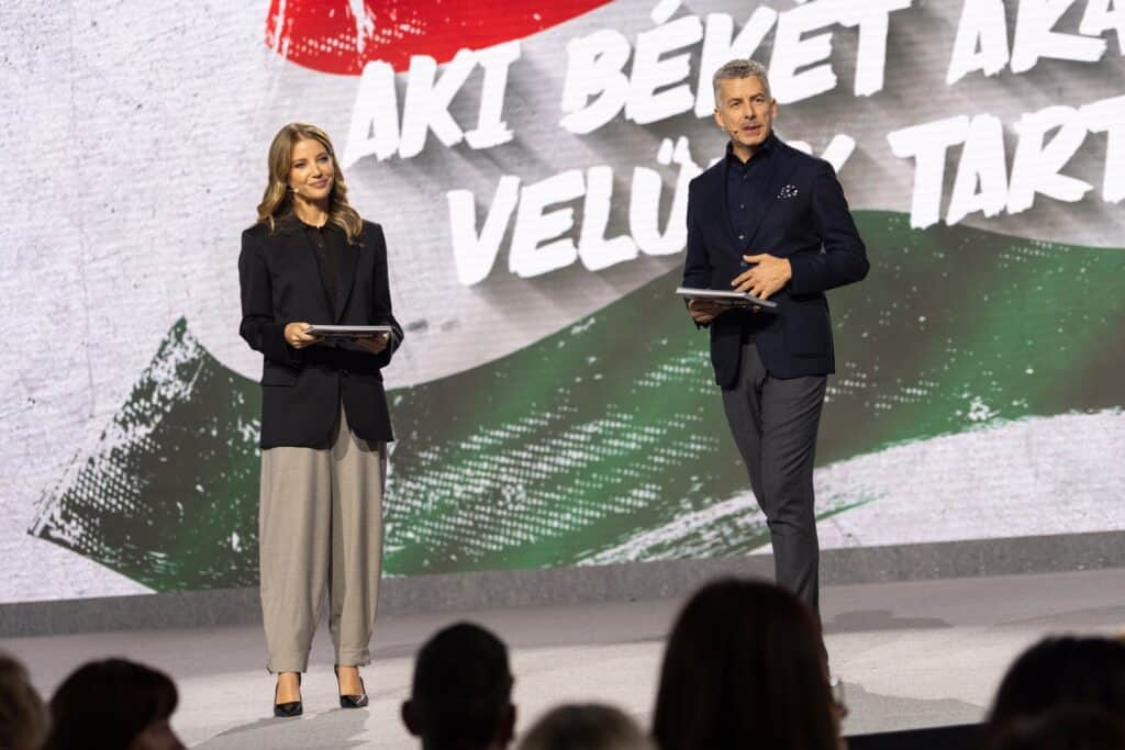 Politikusok fogadnak el beszélgetést a magyar közönségtől egy élő eseményen.