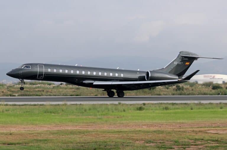 Luxus magánjet - fekete repülőgép a leszállópályán, felhős ég alatt.