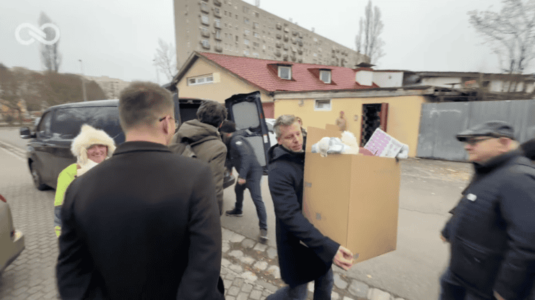 Szociális segélyszállítók láthatók magyarországi utcán, segíteni próbáló önkéntesek.