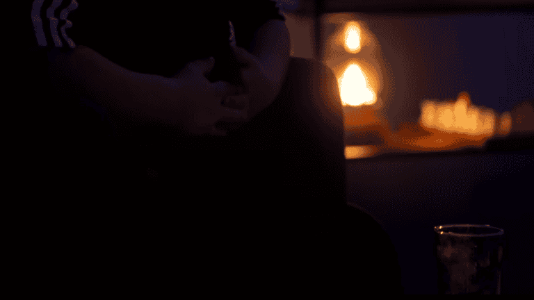 Elalvó személy egy sötétben hangulatos szobában, gyertyafény mellet.