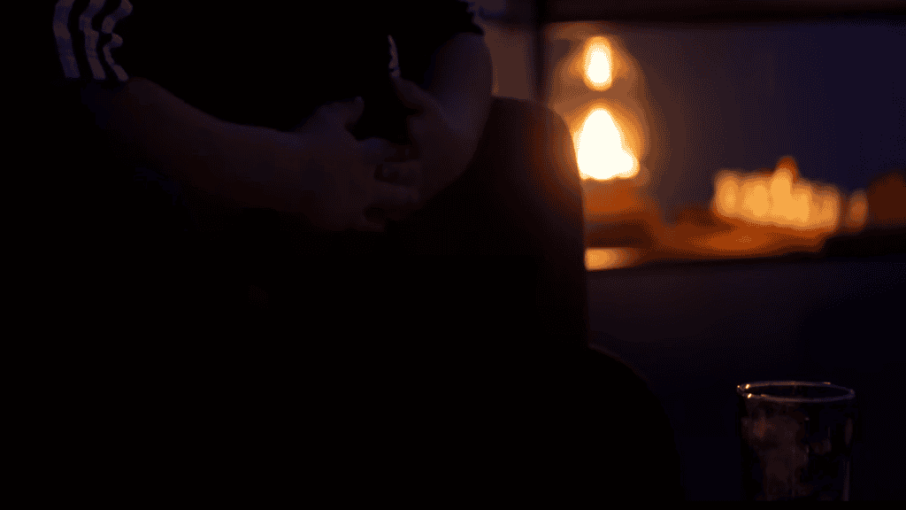 Elalvó személy egy sötétben hangulatos szobában, gyertyafény mellet.