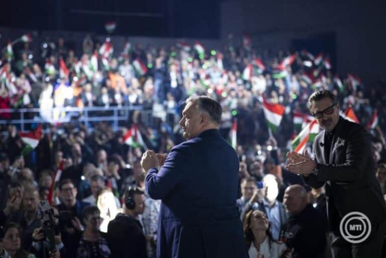 Magyar politikusok és közönség Magyarország nemzeti zászlóival egy nagy ünnepi eseményen.