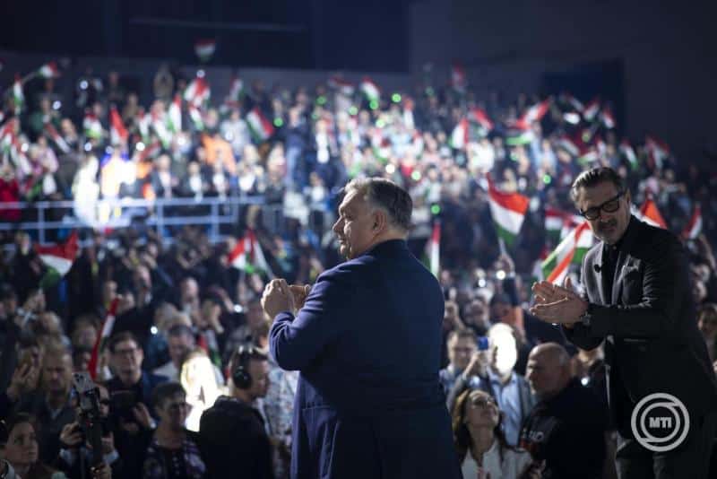 Magyar politikusok és közönség Magyarország nemzeti zászlóival egy nagy ünnepi eseményen.