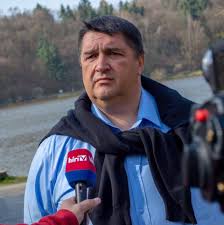 Magyar politikus nyilatkozik egy újságíró kérdésére szabadban, háttérben természet.