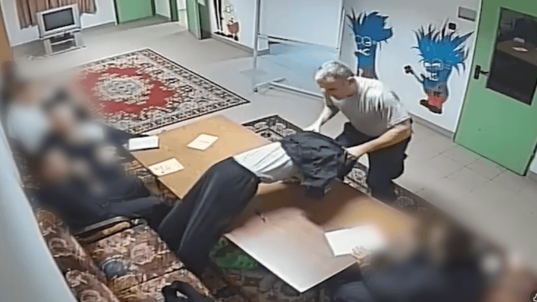 Gyerekek múlik a tanári szobában, miközben a tanár próbálja megállítani őket, kopogtatással és nyomással.