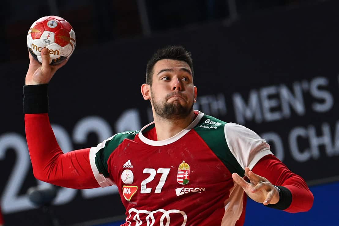 Házi kézi játékos Magyarország címeres melegítőben dobja a labdát.