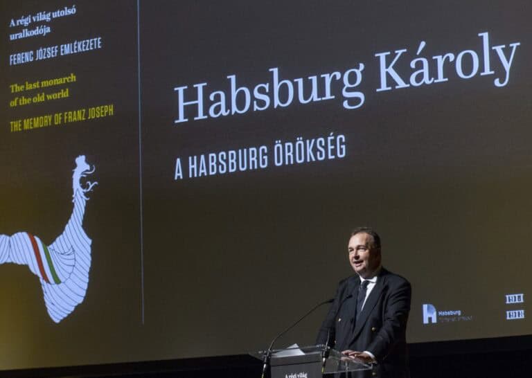Művészeti előadás a Habsburg örökség témakörében, Károllyal a színpadon, magyar nyelvű táblákkal.