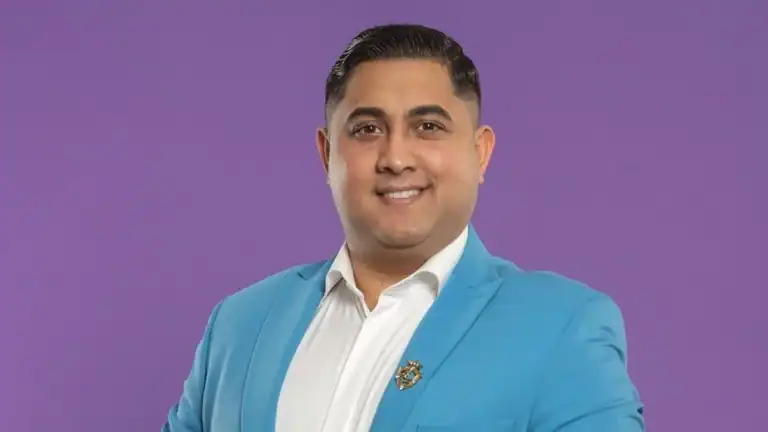 Barátságos férfi portré, kék öltöny, laza párduc mintás háttér.