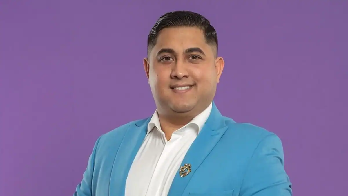 Barátságos férfi portré, kék öltöny, laza párduc mintás háttér.