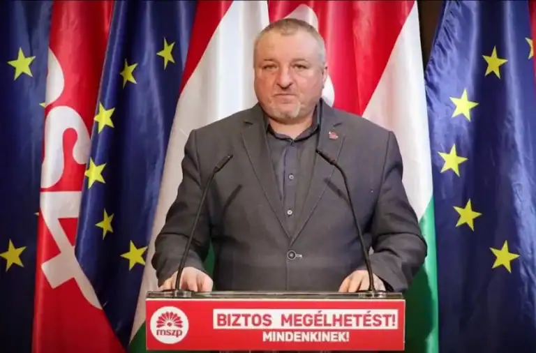 Erős magyar politikus újszülött nyilatkozata, háttérben EU és magyar zászlók.