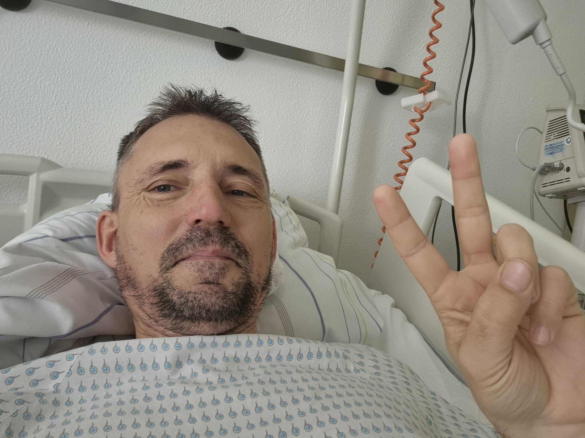 Egészségesnak tűnő beteg az ágyban, kórházi környezetben.