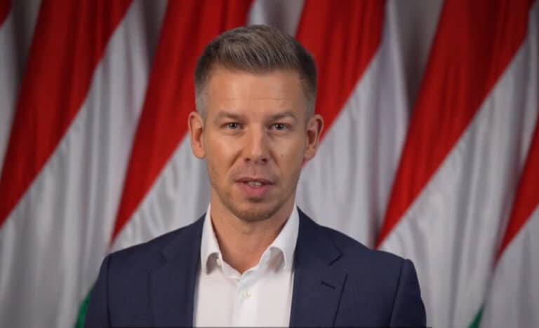 Magyar politikus beszélvány a háttérben nemzeti zászlókkal MagyarNewsOnline híroldal számára.