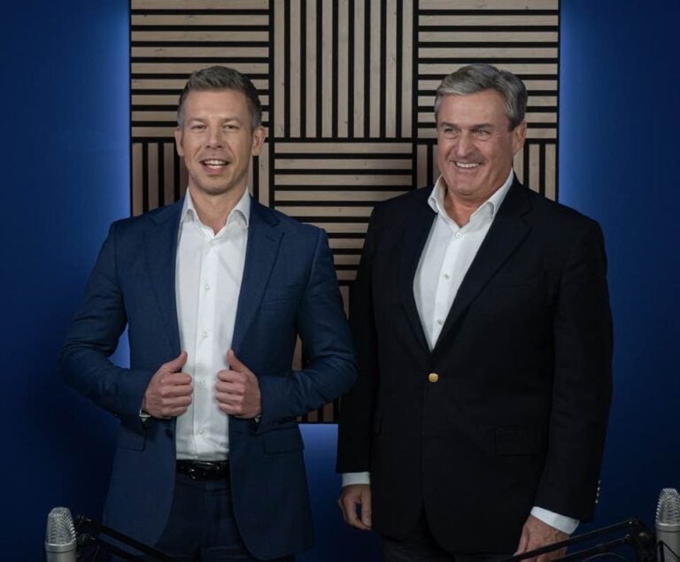 Férfi műsorvezetők profi stúdióban, mosolyogva és magabiztosan állnak.