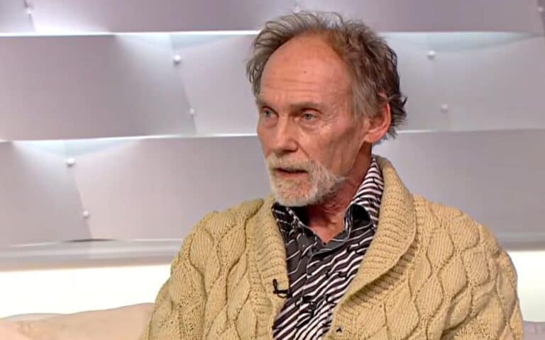 Idősebb férfi beszélget egy műsorban, világos háttérrel.