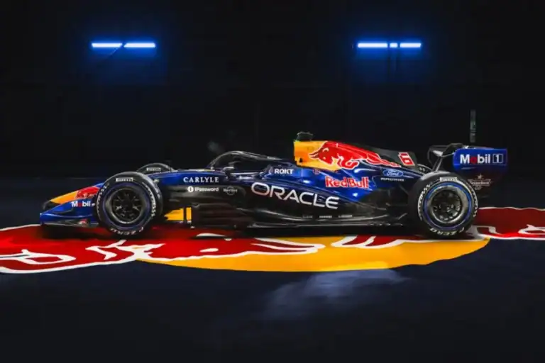 Magyar nyelvű Formula 1 autó a Red Bull Racing csapat színében, sötét háttérrel, a padlón a Red Bull logóval.