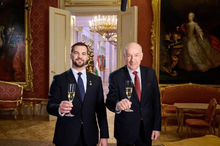 Elegáns férfiak pezsgővel köszöntik az új évet egy díszes szalonban, téli hangulatot és ünnepi dekorációt varázsolva a kép.