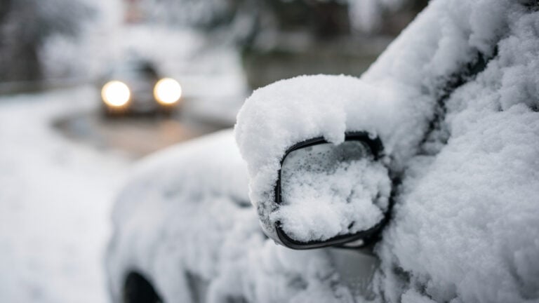 Havas autó híd alatt, hóban, elhomályosodott háttérben, közelről.