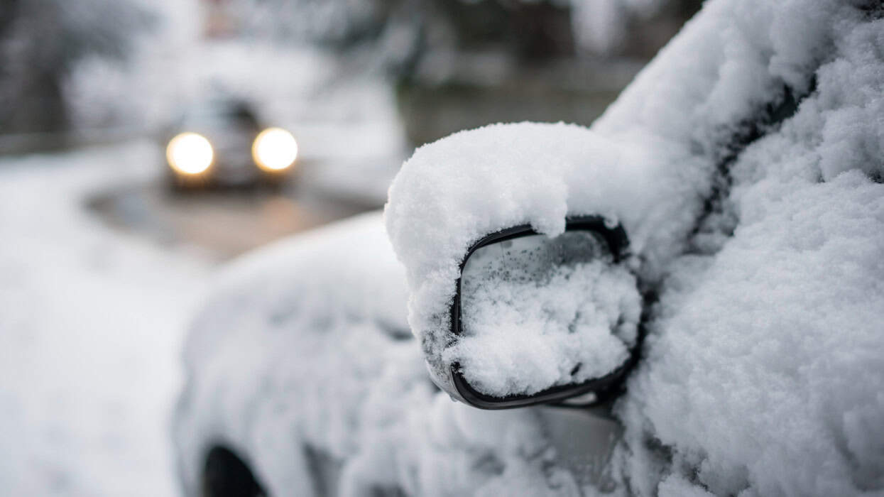 Havas autó híd alatt, hóban, elhomályosodott háttérben, közelről.