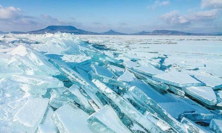Jégdarabok a jeges tó partján, hideg és havas táj Magyarországon.