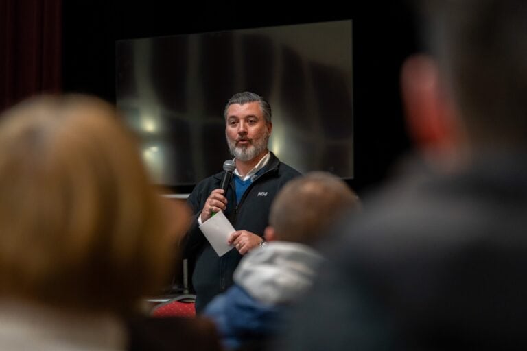 Magyar Péter beszél egy konferencián Marcaliban, háttérben nagy képernyő.