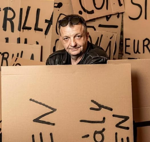 Pesty László portréja egy táblával, körülötte tiltakozó táblák, amelyek a szólásszabadságért és igaz.