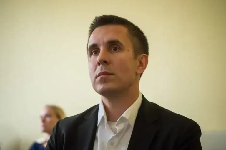 Czeglédy Csaba a bíróság előtt, komoly arckifejezéssel.