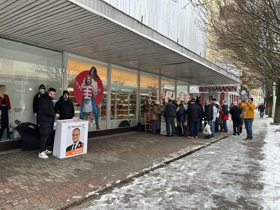 Sorban állnak az emberek a kampányállomásnál, ahol aláírásokat gyűjtenek a Fidesz támogatói.