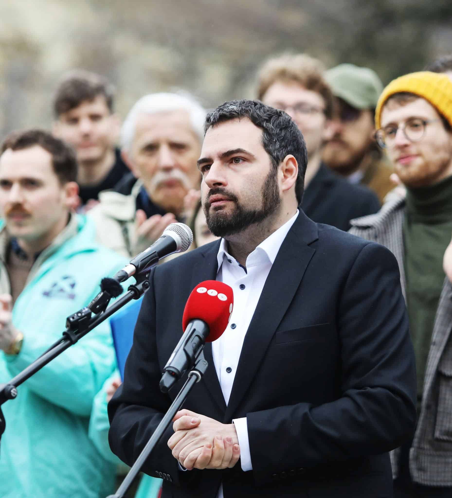 Jámbor András beszédet mond egy politikai eseményen, miközben több ember hallgatja.