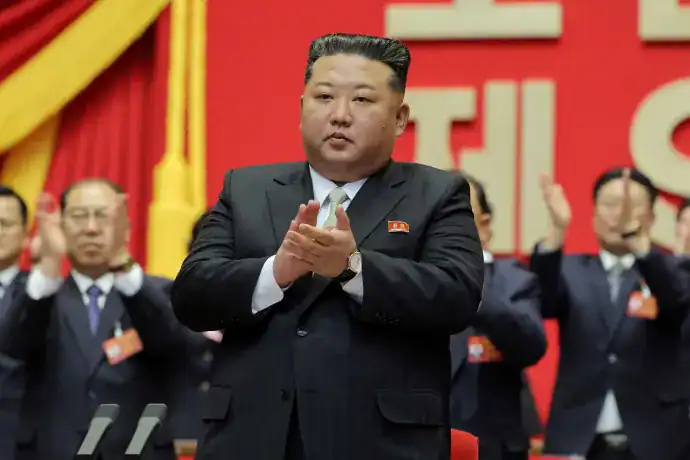 Kim Dzsongun a pártvezetői ceremónián, háttérben más politikusok.