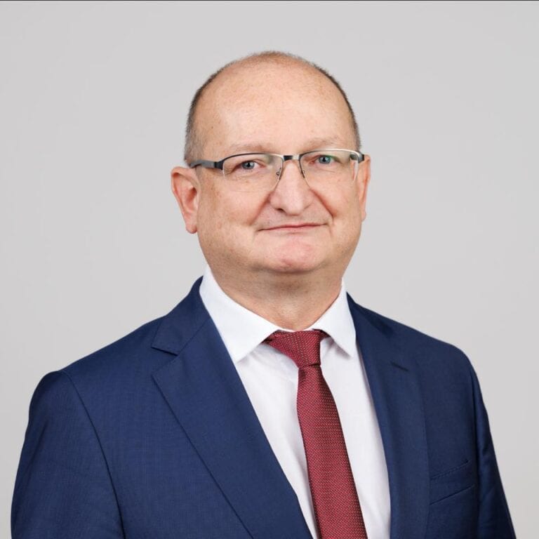 Egy férfi, aki üzleti öltözetben beszél a Tisza folyóról Szombathelyen.