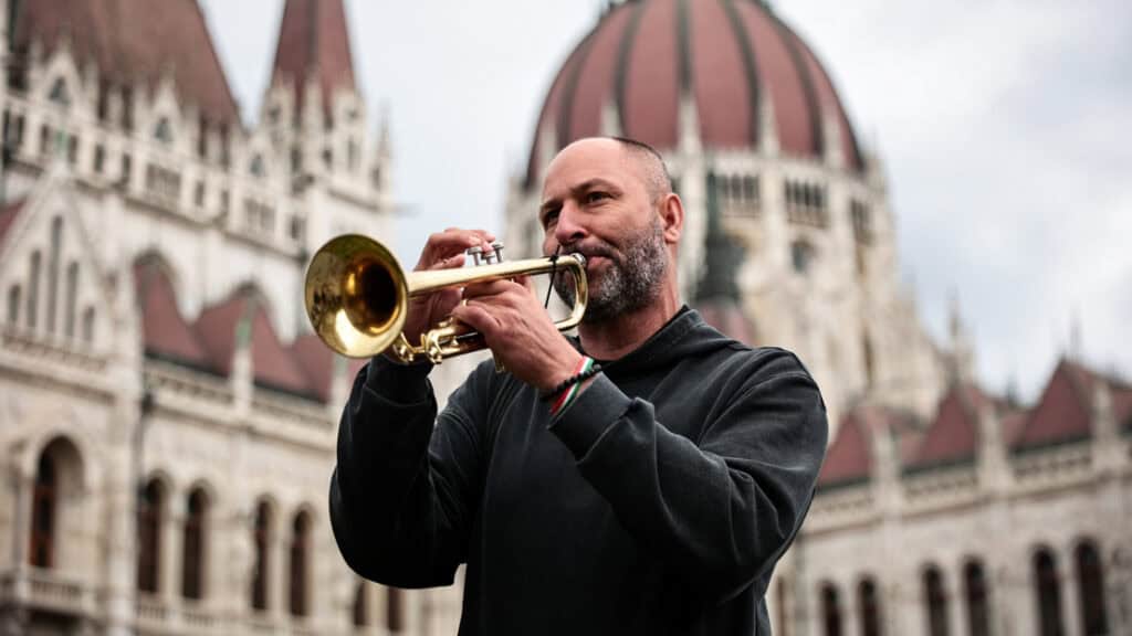 Élethű kép egy trombitásról Budapest Parlement előtt.