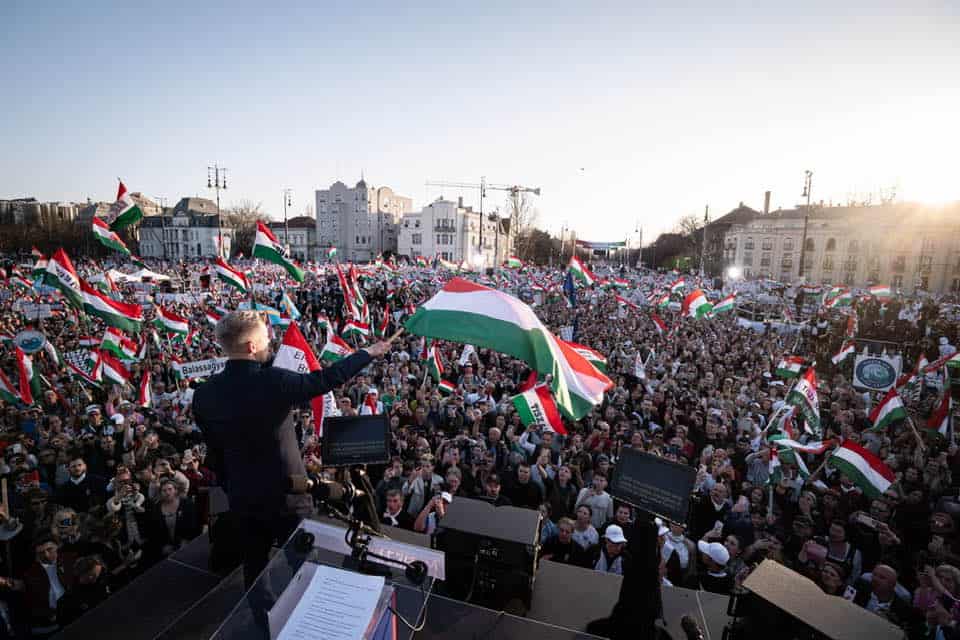 Magyar Péter a tömeg előtt, sok magyar zászlóval az ünnepi eseményen.