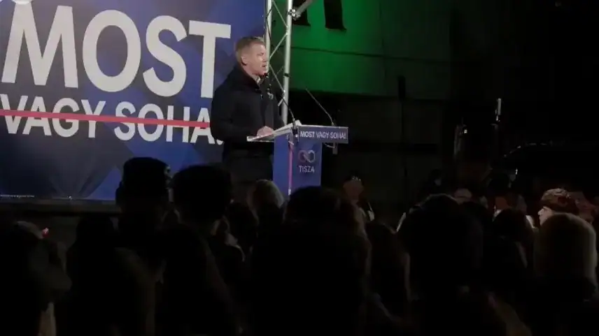 Egy férfi beszél egy rendezvényen, a háttérben a "MOST VAGY SOHA" felirat látható.