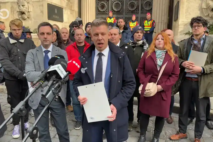 Magyar Péter beszédet mond az ügyészség előtt, médiások és tüntetők körében.