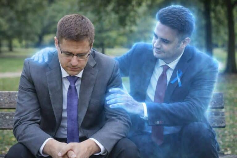 Két férfi beszélget a parkban, egyikük szorosan megérinti a másikat.