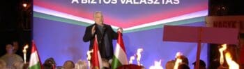 Fidesz politikus beszél a kampánygyűlésen Nagykanizsán, háttérben a "FIDESZ A BIZTOS VÁLASZTÁS" feli.