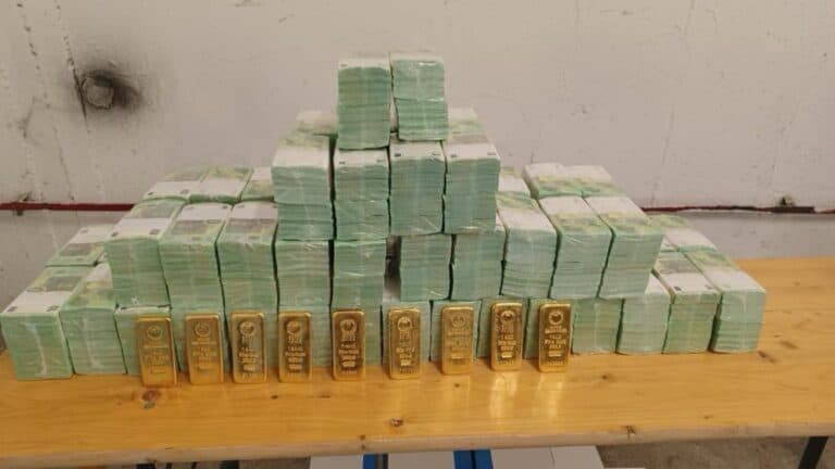 Álló bankjegyek és aranyrudak egy asztalon, a hatóságok által lefoglalt készpénz és értékek.