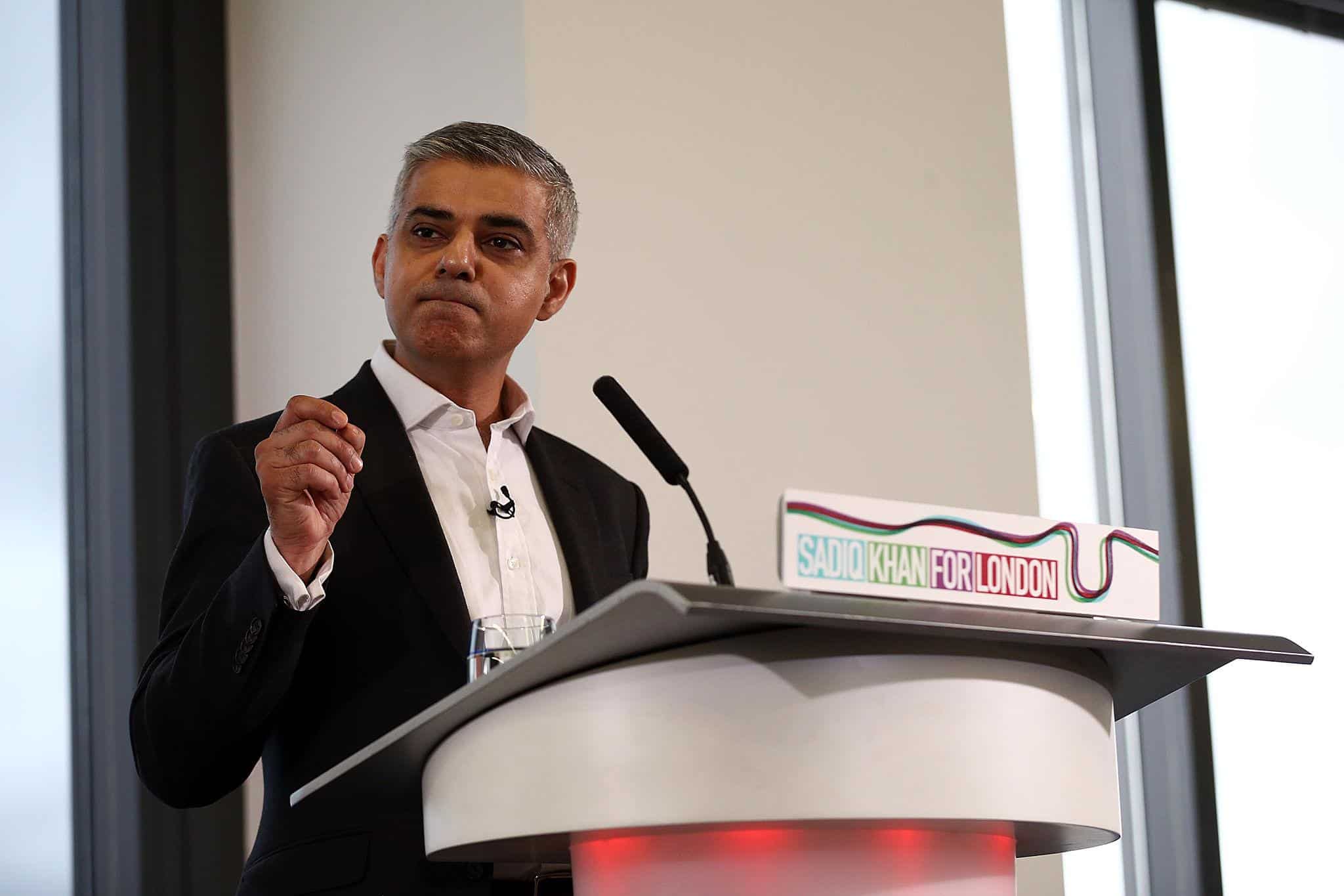Az indiai származású politikus beszédet mond egy konferencián, a háttérben a "Sadiq Khan for London".