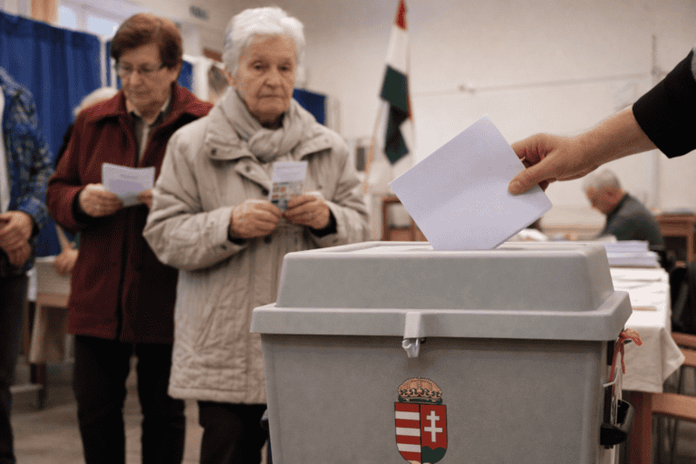 Egy személy leadja szavazatát a szavazóurnába.