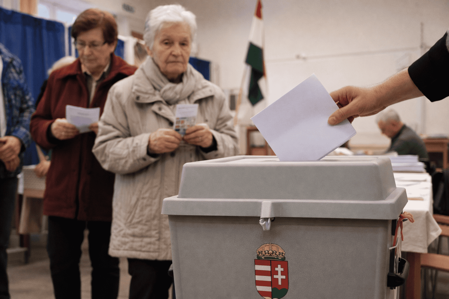 Egy személy leadja szavazatát a szavazóurnába.