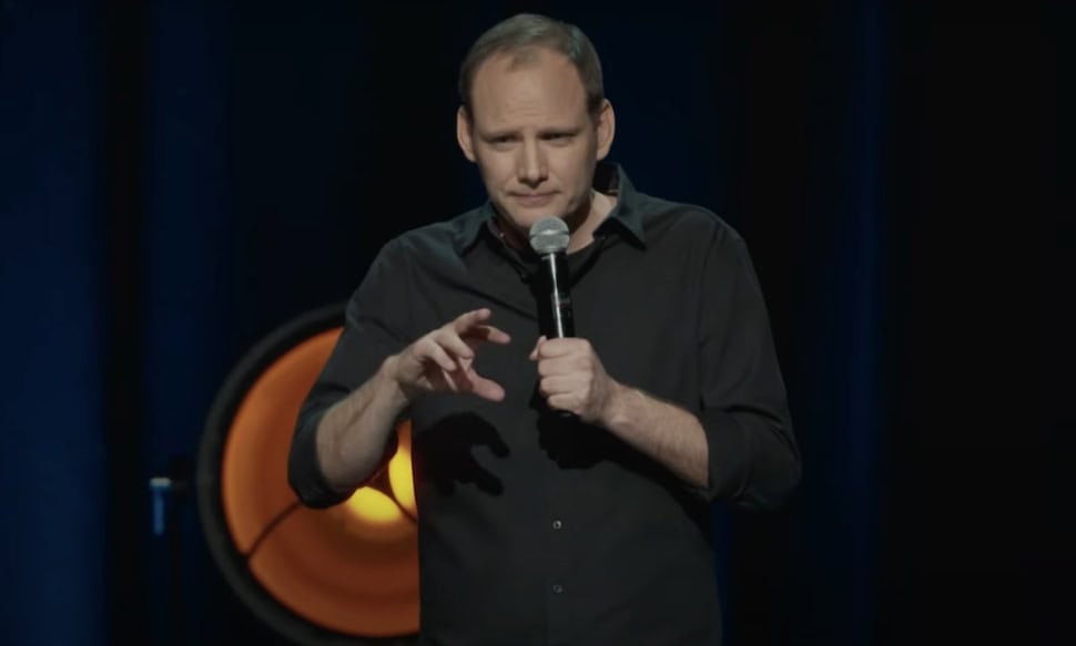 Bödőcs Tibor humorista színpadon, mikrofonral a kezében.