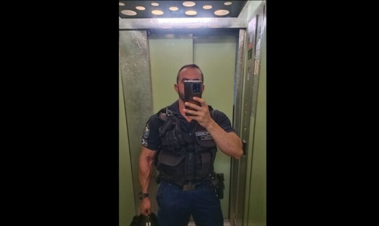 Egy rendőr készít selfie-t az emelőben, fekete egyenruhában és hátizsákkal.